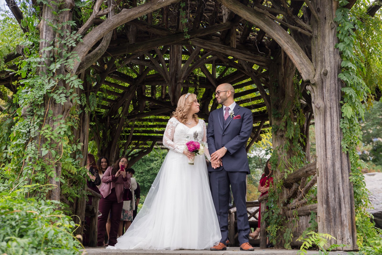 Bride and groom hand in hand at the ivy-covered Dene Summerhouse - Central Park Wedding - New York City